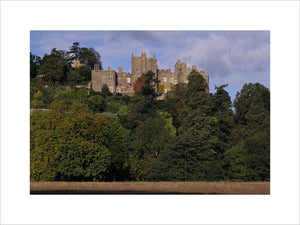 A general view of Dunster Castle from the south, with dense woodland in the foreground
