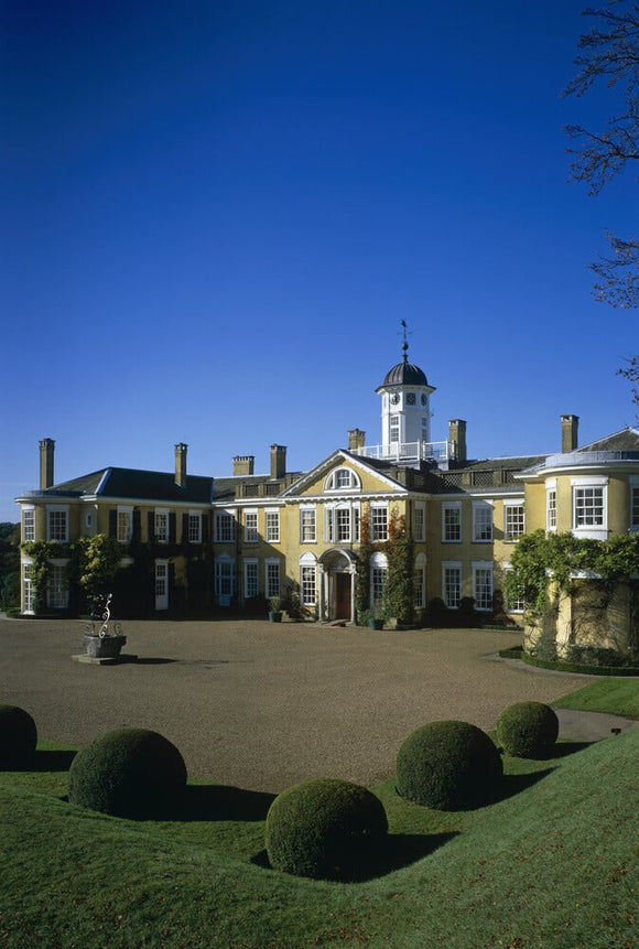 Polesden Lacey house, the beautiful east front with round topiary bushes in foreground